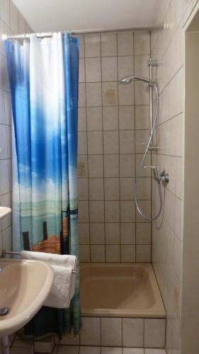 uma casa de banho com um chuveiro, uma banheira e um lavatório. em Zur Mühle em Bocholt