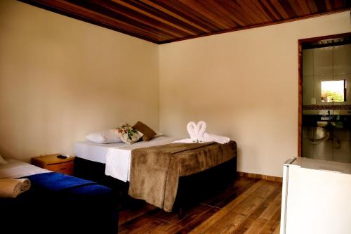 a room with two beds and a couch at Chalés do Laurindo in Maciel