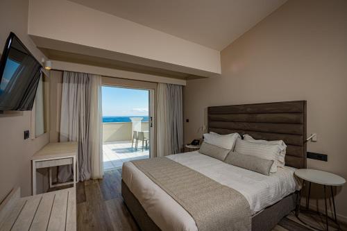 a bedroom with a bed and a view of the ocean at Alexandra Beach Resort & Spa in Tsilivi