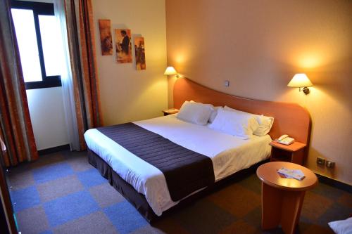 En eller flere senge i et værelse på Aeroport Hotel - Parc Expo