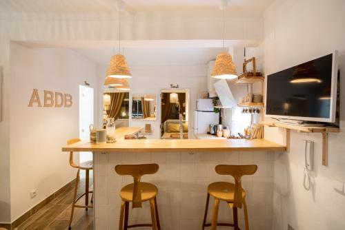 a kitchen with two stools at a kitchen counter with a bar at Baixa de Faro Rooftop in Faro