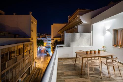 a balcony with a table and chairs at night at Baixa de Faro Rooftop in Faro