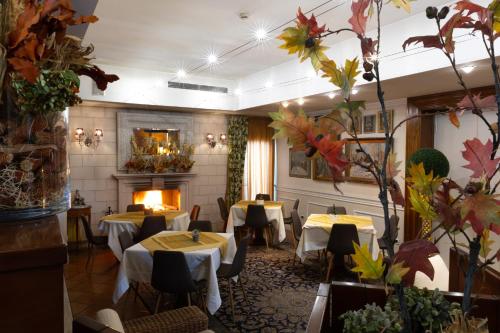 a restaurant with tables and chairs and a fireplace at Hotel Locanda Al Sole in Castello di Godego