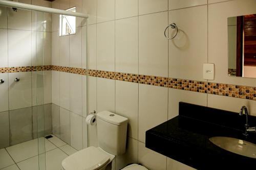 a bathroom with a toilet and a sink and a shower at Chalés do Laurindo in Maciel