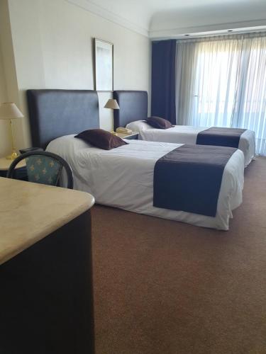 a hotel room with two beds and a desk at Departamento Céntrico in Rosario