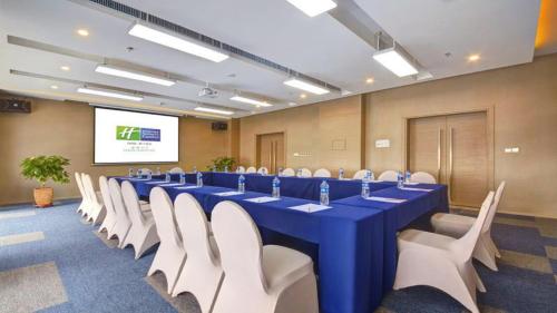 a conference room with a long blue table and white chairs at Holiday Inn Express Panjin Downtown by IHG in Panjin