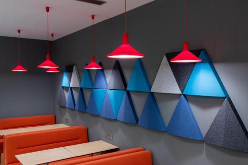 une salle à manger avec des chaises et des lumières colorées dans l'établissement Holiday Inn Express Porto Exponor by IHG, à Leça da Palmeira