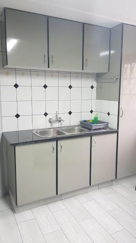 a kitchen with white cabinets and a sink at Bethel B&B / Selfcatering in George