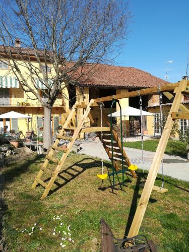 a wooden swing set in a park with a tree at L'Adele Bed & Breakfast in Occimiano