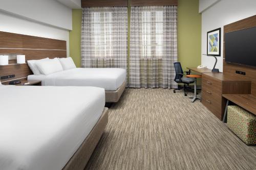 a hotel room with two beds and a flat screen tv at Holiday Inn Express San Antonio North Riverwalk Area by IHG in San Antonio
