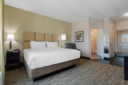 a hotel room with a large bed and a desk at Candlewood Suites - San Antonio Lackland AFB Area by IHG in San Antonio
