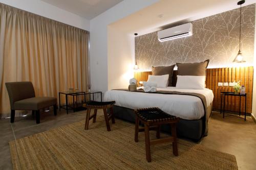 a hotel room with a large bed and a chair at Cosmopolis Multi-Venue in Larnaca