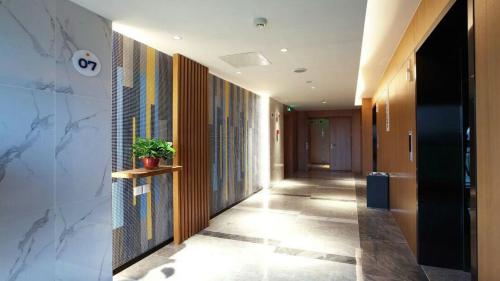 a hallway of an office building with a plant on a shelf at Holiday Inn Express Xi'an Qujiang South by IHG in Xi'an
