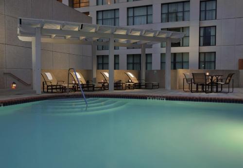 uma piscina com cadeiras e mesas e um edifício em Holiday Inn San Antonio-Riverwalk, an IHG Hotel em San Antonio