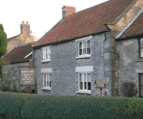 a stone building with a sign in front of it at Manor Farm Bed & Breakfast in Gillamoor