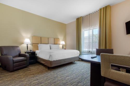 a hotel room with a bed and a chair at Candlewood Suites - San Antonio Lackland AFB Area by IHG in San Antonio