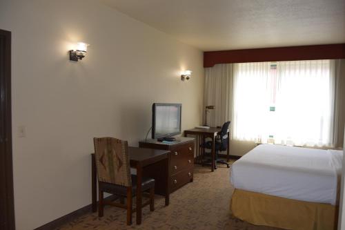 a hotel room with a bed and a desk and a television at Hyatt Place Springdale - Zion National Park in Springdale