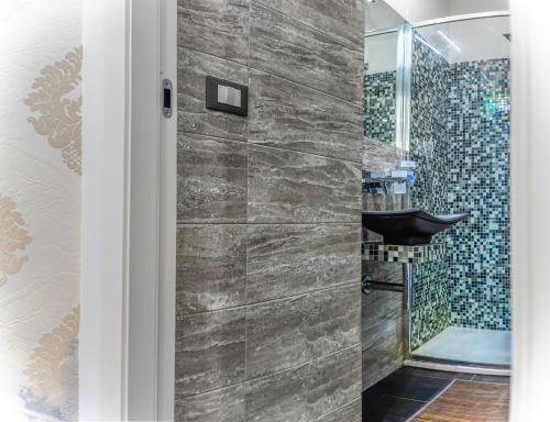 a bathroom with a sink and a shower at Tribunale Basement Apartment in Messina