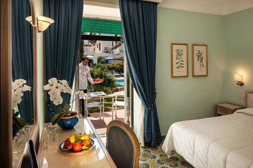 a room with a bed and a table with a bowl of fruit at Hotel Continental Ischia in Ischia