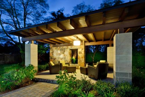 a patio with a wooden pergola at night at Hotel Indigo East End by IHG in Riverhead