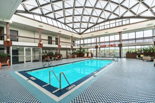 uma grande piscina num edifício com tecto de vidro em Holiday Inn & Suites Pittsfield-Berkshires, an IHG Hotel em Pittsfield