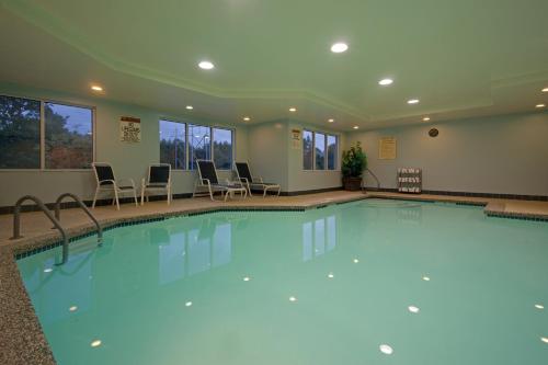 羅切斯特的住宿－羅徹斯特智選假日酒店&套房，大楼内带桌椅的大型游泳池