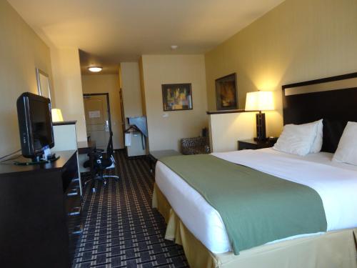 a hotel room with a bed and a flat screen tv at Holiday Inn Express and Suites Limerick - Pottstown by IHG in Limerick