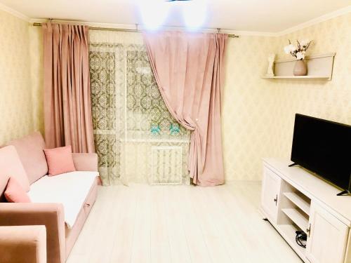 ein Wohnzimmer mit einem Sofa und einem TV in der Unterkunft Classic Apartment in Boryspil