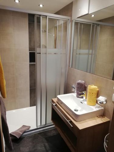 a bathroom with a shower and a white sink at Vermunt - Silvretta Sommer Premium Card inklusive in Galtür