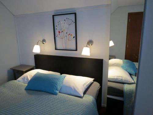 a bedroom with two beds with blue and white pillows at Hotel Schilberg in Slenaken