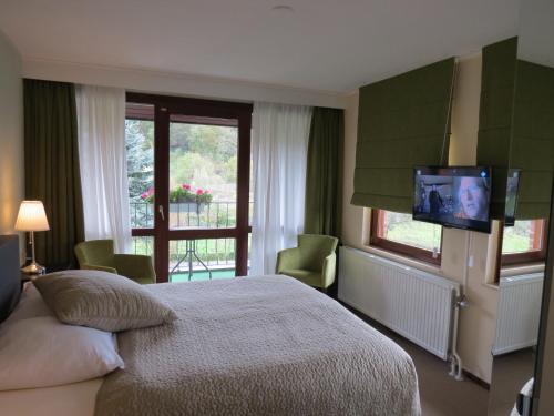 a bedroom with a bed and a tv on the wall at Hotel Residentie Slenaeken in Slenaken