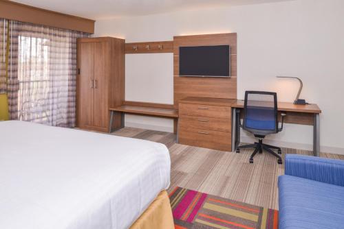 a hotel room with a bed and a desk with a computer at Holiday Inn Express Palm Desert by IHG in Palm Desert