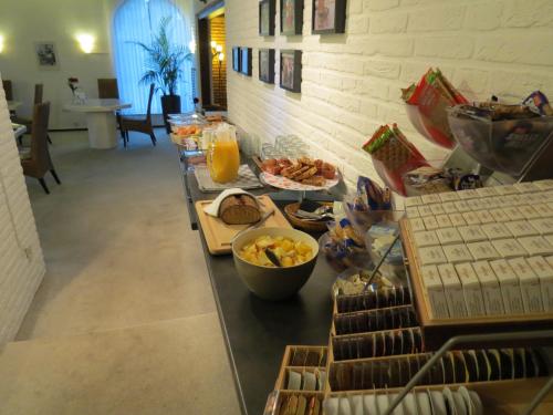 a buffet line with breakfast foods and orange juice at Hotel Schilberg in Slenaken