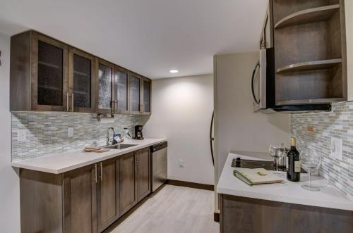 a kitchen with wooden cabinets and a refrigerator at Candlewood Suites Richmond - West Broad, an IHG Hotel in Richmond