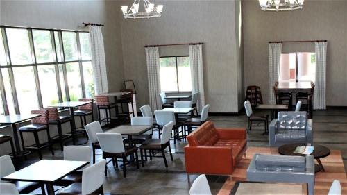 a dining room with tables and chairs and windows at Holiday Inn Express Hotels & Suites Rockingham West by IHG in Rockingham