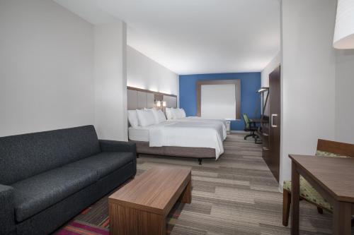 une chambre d'hôtel avec un lit et un canapé dans l'établissement Holiday Inn Express Slidell, an IHG Hotel, à Slidell