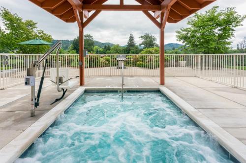 a hot tub in a patio with an umbrella at Holiday Inn Express Roseburg by IHG in Roseburg