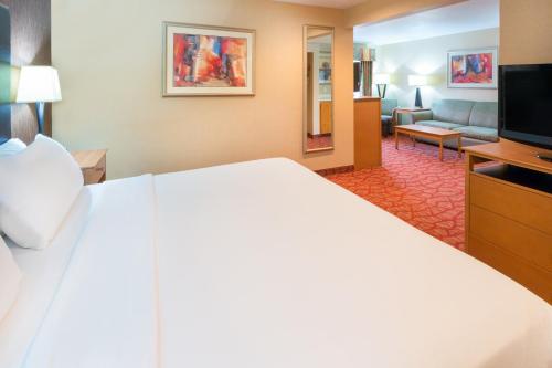 a hotel room with a large bed and a living room at Holiday Inn Express Roseburg by IHG in Roseburg