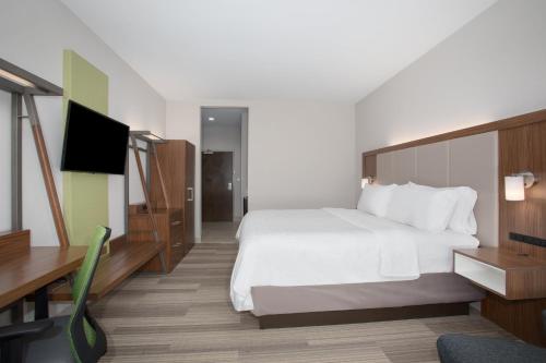 a hotel room with a bed and a flat screen tv at Holiday Inn Express Slidell by IHG in Slidell
