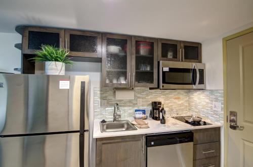 a kitchen with a sink and a refrigerator at Candlewood Suites Richmond - West Broad by IHG in Richmond