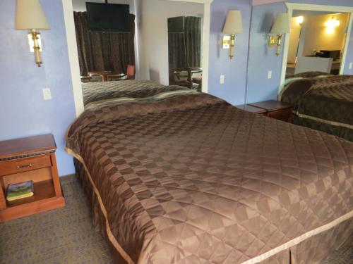 Habitación de hotel con cama grande y espejo en Park Cienega Motel, en Los Ángeles