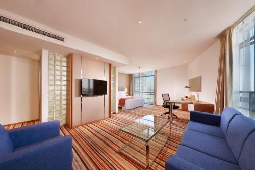 a living room with a blue couch and a tv at Holiday Inn Express Shanghai Jiading Industry Park by IHG in Jiading