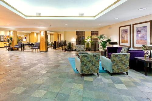 a lobby of a hotel with chairs and tables at Holiday Inn Express Hotel & Suites San Antonio - Rivercenter Area by IHG in San Antonio
