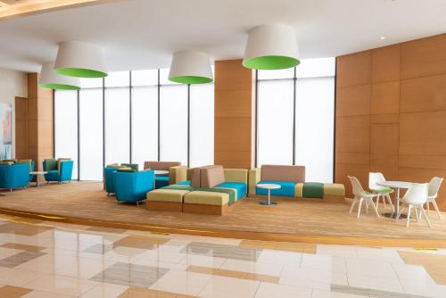 a lobby with chairs and tables and windows at Holiday Inn Express Shanghai Jiading Industry Park by IHG in Jiading