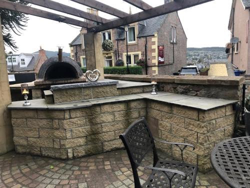 an outdoor bar with a pizza oven on a patio at Redcliffe Hotel in Inverness
