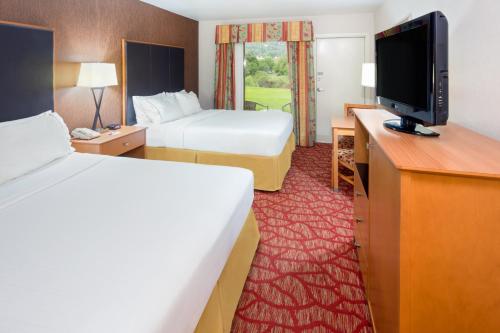 a hotel room with two beds and a flat screen tv at Holiday Inn Express Roseburg by IHG in Roseburg