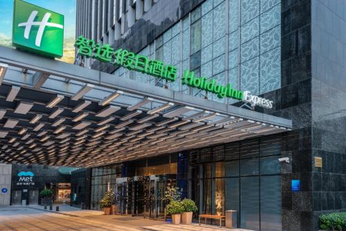 ein Gebäude mit einem Schild an der Seite in der Unterkunft Holiday Inn Express Shanghai Jinsha by IHG in Shanghai