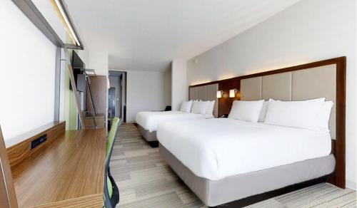 a hotel room with two beds and a flat screen tv at Holiday Inn Express Slidell by IHG in Slidell