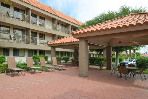 a patio with tables and chairs in front of a hotel at Holiday Inn Express Palm Desert by IHG in Palm Desert