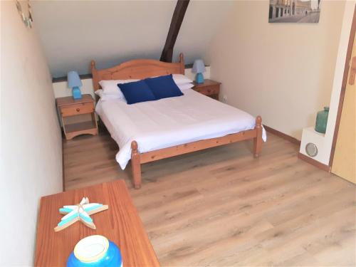 een slaapkamer met een bed en een houten tafel bij Ty Kena in Saint-Gilles-du-Vieux-Marché